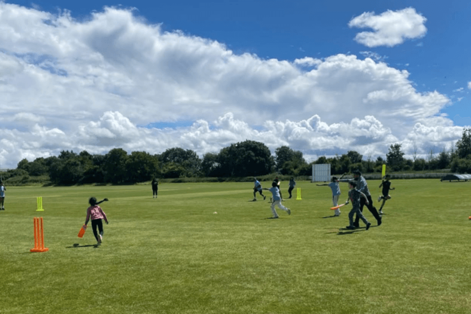 Children playing Dynamos cricket at WICC - action shot of kids running between wickets on a sunny day